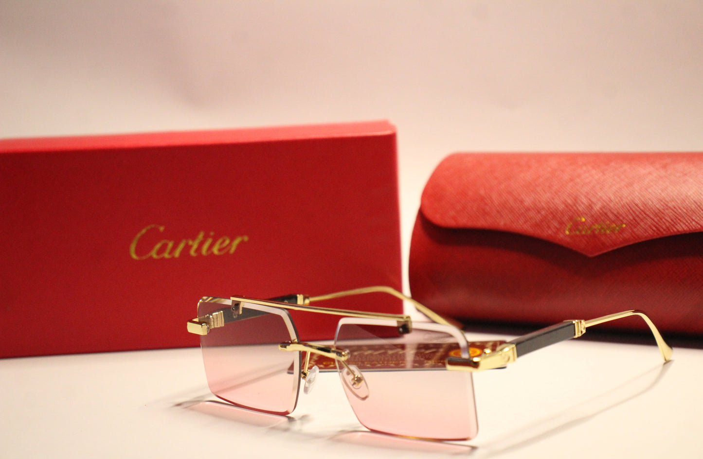 Three piece Cartier sunglasses – with golden Frame and pink Gradient Lenses.
